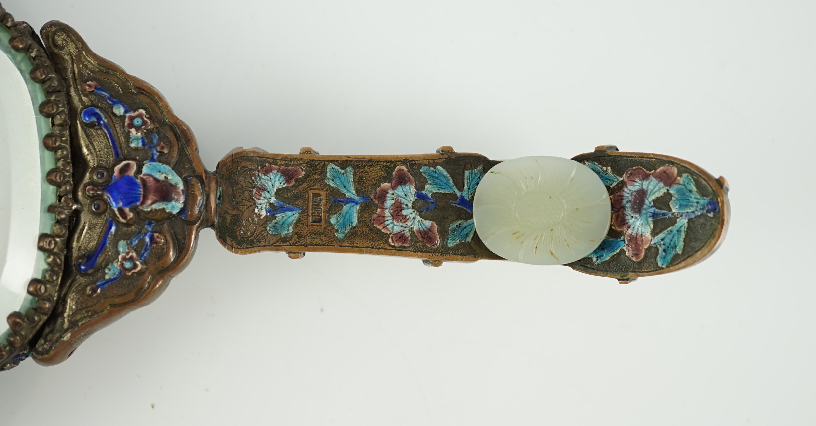 An early 20th century Chinese enamelled copper hand mirror with 18th/19th century Chinese pale celadon jade mounts